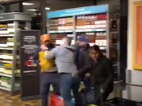 In a screengrab from video posted to X, a bystander in a grey shirt confronts two men and a woman during a theft from an LCBO in Etobicoke.